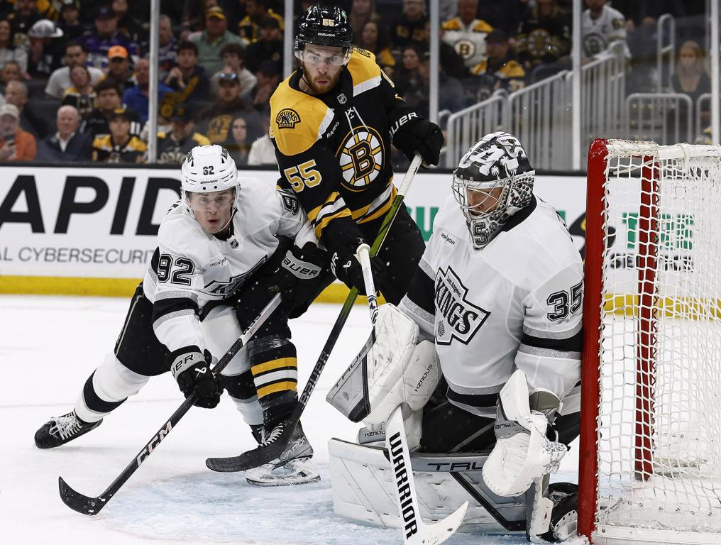 BOSTON, MA - OCTOBER 12: Brandt Clarke #92 of the Los Angeles Kings and Justin Brazeau #55 of the Boston Bruins eye a loose puck in front of goaltender Darcy Kuemper #35 during the first period at TD Garden on October 12, 2024 in Boston, Massachusetts. (Photo By Winslow Townson/Getty Images)