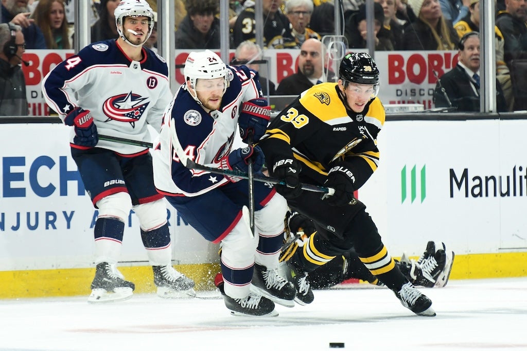 Dec 28, 2024; Boston, Massachusetts, USA; Columbus Blue Jackets right wing Mathieu Olivier (24) and Boston Bruins center Morgan Geekie (39) battle for a loose puck during the second period at TD Garden. Mandatory Credit: Bob DeChiara-Imagn Images