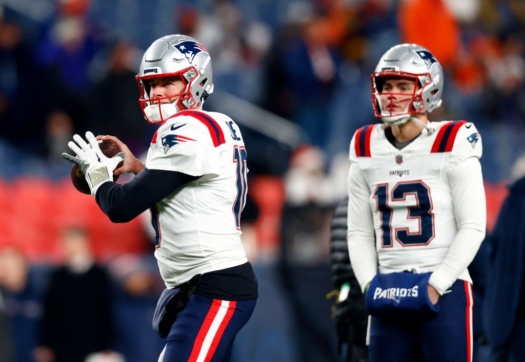 DENVER, COLORADO - DECEMBER 24: Quarterback Mac Jones #10 of the New England Patriots warms up as quarterback Nathan Rourke #13 watches prior to the game against the Denver Broncos at Empower Field At Mile High on December 24, 2023 in Denver, Colorado. (Photo by Justin Edmonds/Getty Images)