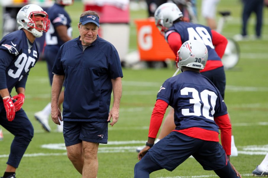 New England Patriots head coach Bill Belichick, left, talks with cornerback Jason McCourty (30) during organized team activities at Gillette practice fields.