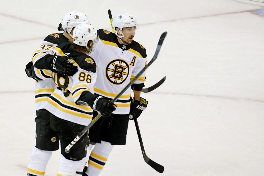 Aug 31, 2020; Toronto, Ontario, CAN; Boston Bruins right wing David Pastrnak (88) celebrates his goal against the Tampa Bay Lightning with center Patrice Bergeron (left) and left wing Brad Marchand (63) during the second period in game five of the second round of the 2020 Stanley Cup Playoffs at Scotiabank Arena. Mandatory Credit: Dan Hamilton-USA TODAY Sports