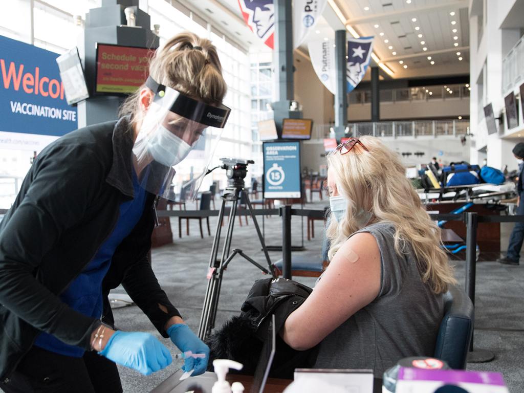 FOXBOROUGH, MA - JANUARY 15: A nurse with a woman following her COVID-19 vaccination at the Gillette Stadium vaccinations site on January 15, 2021. (Photo by Scott Eisen/Getty Images)