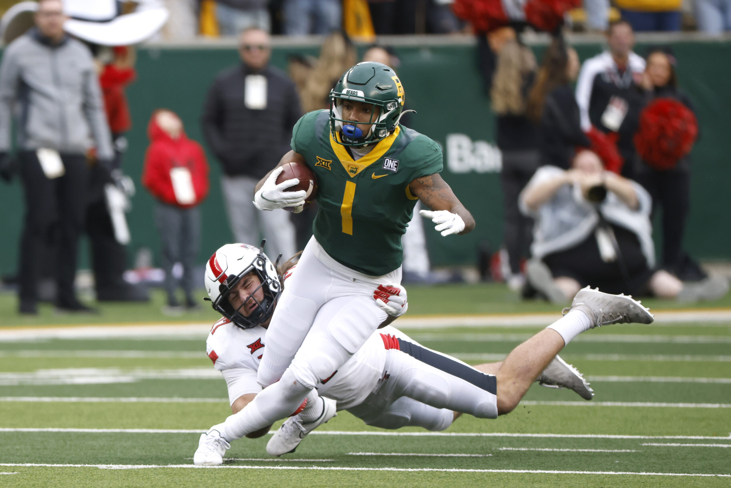 WACO, TX -NOVEMBER 27: Trestan Ebner #1 of the Baylor Bears carries the ball past Colin Schooler #17 of the Texas Tech Red Raiders in the first half at McLane Stadium on November 27, 2021 in Waco, Texas. (Photo by Ron Jenkins/Getty Images)