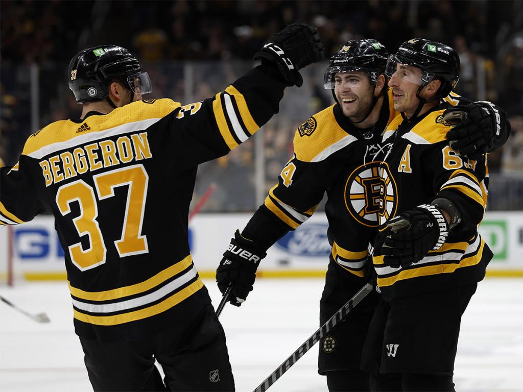 Apr 26, 2022; Boston, Massachusetts, USA; Boston Bruins left wing Brad Marchand (63) is congratulated by left wing Jake DeBrusk (74) and center Patrice Bergeron (37) after scoring against the Florida Panthers during the third period at TD Garden. Mandatory Credit: Winslow Townson-USA TODAY Sports