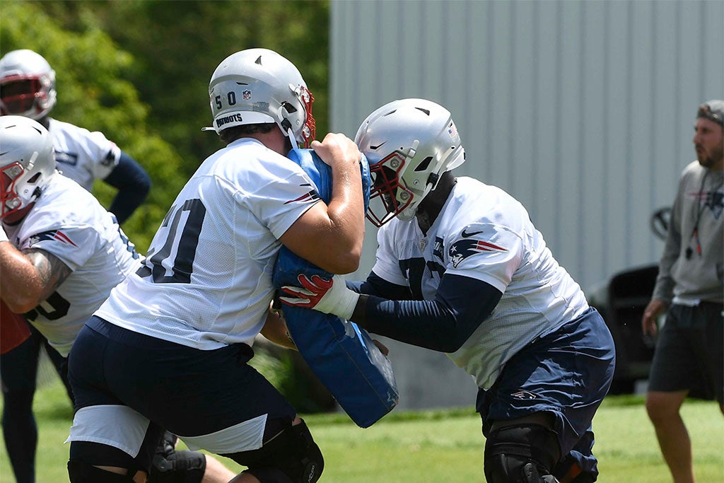 May 23, 2022; Foxborough, MA, USA; New England Patriots offensive lineman Cole Strange works on a blocking drill with offensive tackle Trent Brown (77) (right) Mandatory Credit: Eric Canha-USA TODAY Sports