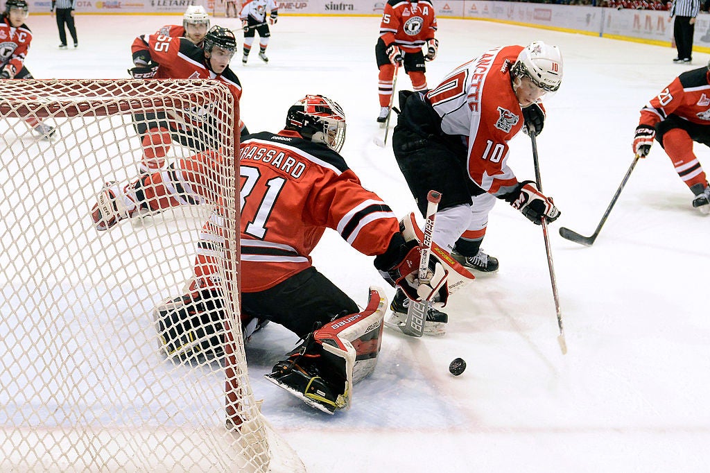 DRUMMONDVILLE, QC - FEBRUARY 23: Francois Brassard #31 of the Quebec Remparts stops the puck on an attempt by Christophe Lalancette #10 of the Drummondville Voltigeurs during the QMJHL game at the Centre Marcel Dionne on February 23, 2014 in Drummondville, Quebec, Canada. (Photo by Richard Wolowicz/Getty Images)