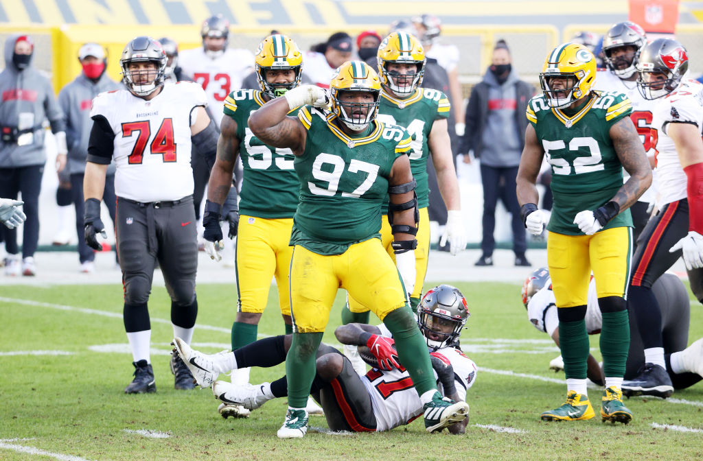 GREEN BAY, WISCONSIN - JANUARY 24: Kenny Clark #97 of the Green Bay Packers celebrates after stopping Ronald Jones #27 of the Tampa Bay Buccaneers in the second quarter during the NFC Championship game at Lambeau Field on January 24, 2021 in Green Bay, Wisconsin. (Photo by Dylan Buell/Getty Images)