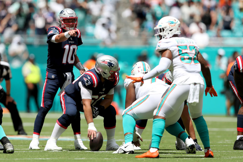 MIAMI GARDENS, FLORIDA - SEPTEMBER 11: Mac Jones #10 of the New England Patriots gestures at the line of scrimmage during the first half against the Miami Dolphins at Hard Rock Stadium on September 11, 2022 in Miami Gardens, Florida. (Photo by Megan Briggs/Getty Images)