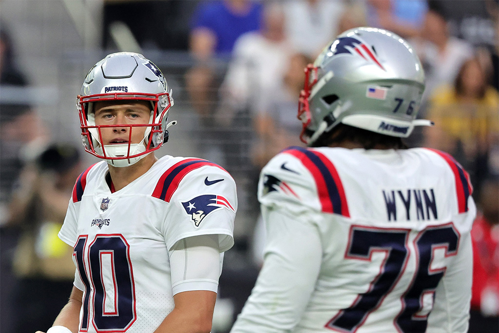 LAS VEGAS, NEVADA - AUGUST 26: Quarterback Mac Jones #10 and offensive tackle Isaiah Wynn #76 of the New England Patriots stand on the field during a preseason game against the Las Vegas Raiders at Allegiant Stadium on August 26, 2022 in Las Vegas, Nevada. The Raiders defeated the Patriots 23-6. (Photo by Ethan Miller/Getty Images)