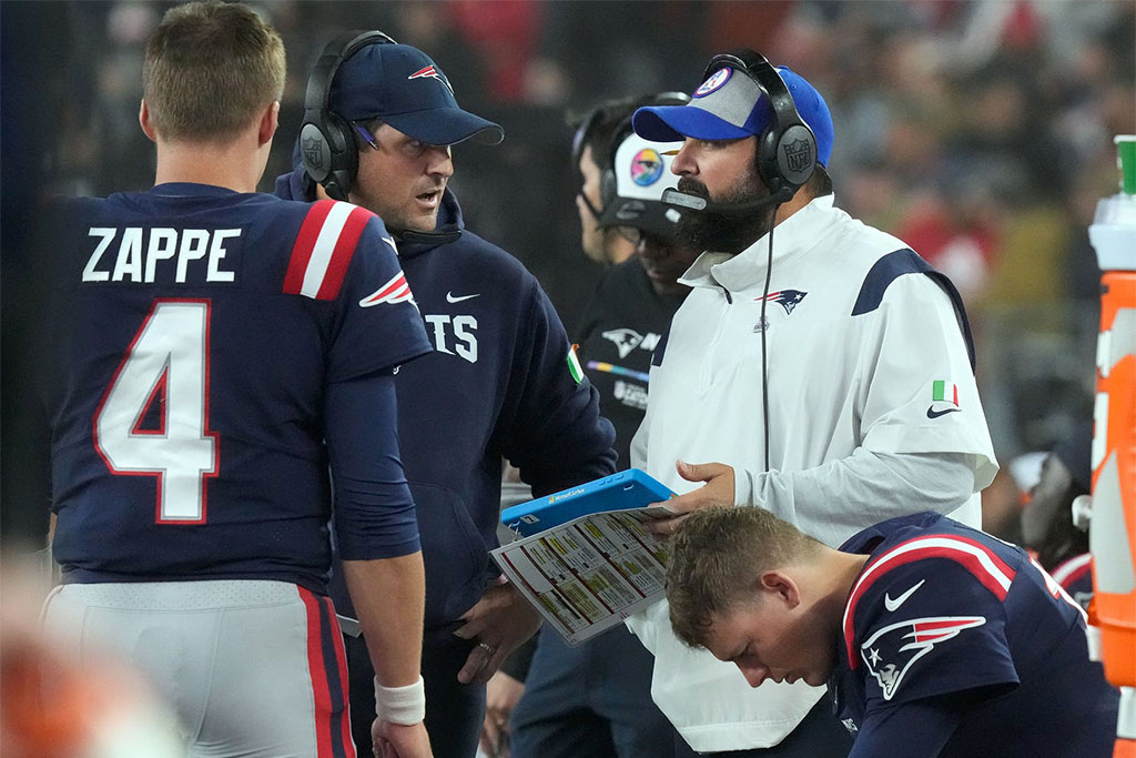 Patriot coaches Joe Judge and Matt Patricia confer as they talk with QN Bailey Zappe as QB Mac Jones studies his play list on his wrist after Jones was replaced by Zappe during the 2nd quarter. (Credit: Providence Journal)