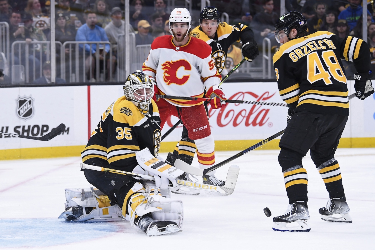 Nov 10, 2022; Boston, Massachusetts, USA; Boston Bruins goaltender Linus Ullmark (35) makes a save while Calgary Flames defenseman Noah Hanifin (55) looks on during the second period at TD Garden. Mandatory Credit: Bob DeChiara/USA TODAY Sports