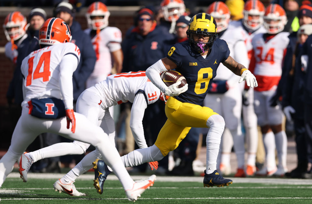 ANN ARBOR, MICHIGAN - NOVEMBER 19: Ronnie Bell #8 of the Michigan Wolverines looks for yards after a first half catch next to Xavier Scott #14 of the Illinois Fighting Illini at Michigan Stadium on November 19, 2022 in Ann Arbor, Michigan. (Photo by Gregory Shamus/Getty Images)
