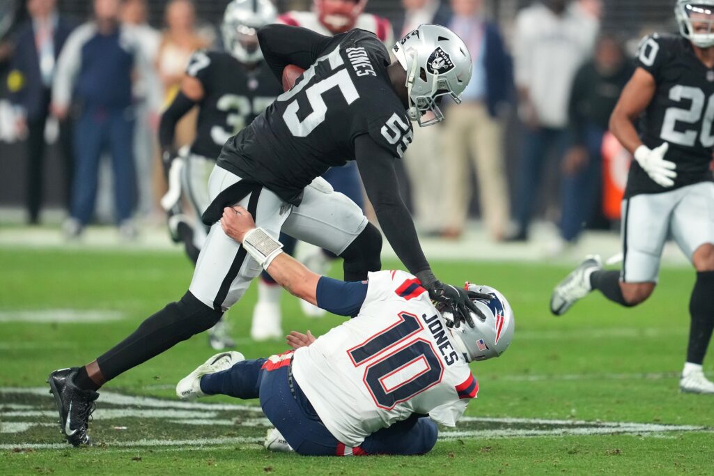 Dec 18, 2022; Paradise, Nevada, USA; Las Vegas Raiders defensive end Chandler Jones (55) stiff-arms New England Patriots quarterback Mac Jones (10) on the way to scoring a touchdown at the end of the second half at Allegiant Stadium. Credit: Stephen R. Sylvanie-USA TODAY Sports