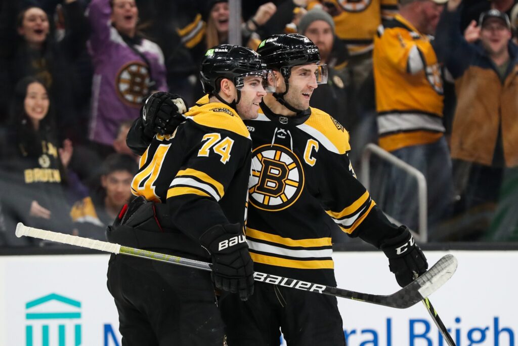 Dec 19, 2022; Boston, Massachusetts, USA; Boston Bruins center Patrice Bergeron (37) and Boston Bruins left wing Jake DeBrusk (74) celebrate after a goal by Bergeron during the third period at TD Garden. Mandatory Credit: Paul Rutherford/USA TODAY Sports