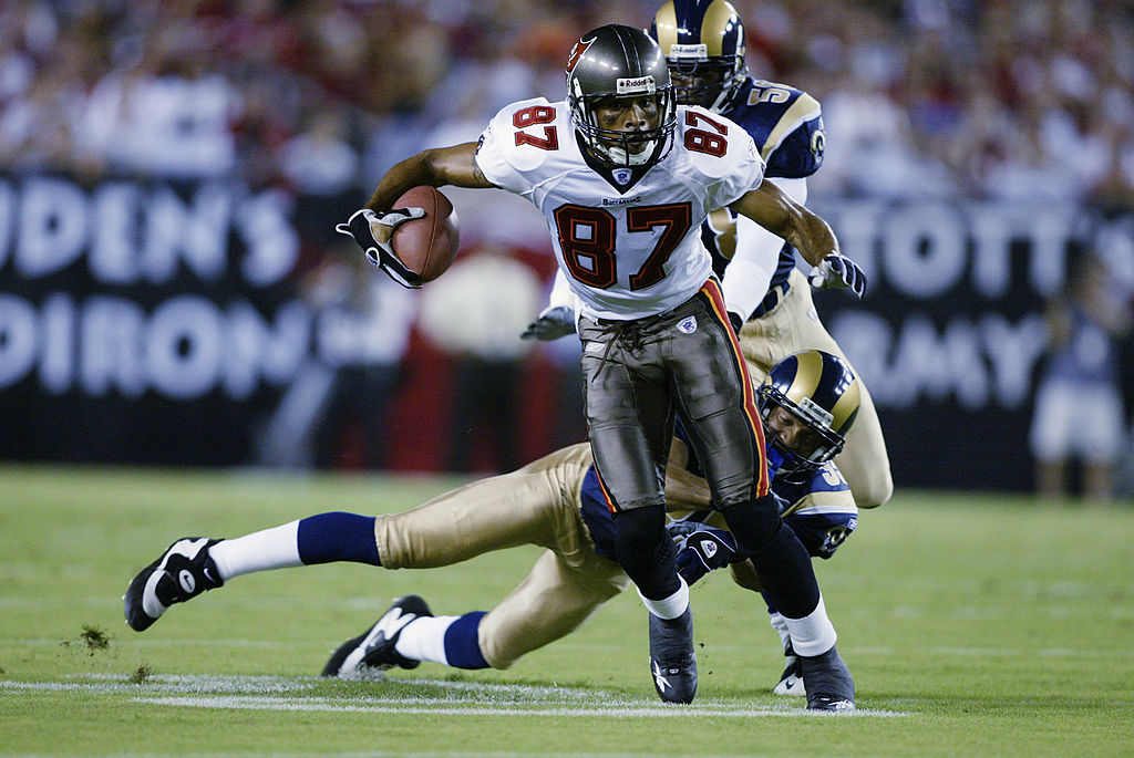 TAMPA, FL - SEPTEMBER 23:  Keenan McCardell #87 of the Tampa Bay Buccaneers runs with the ball while Aeneas Williams #35 of the St. Louis Rams tries to tackle him during the game on September 23, 2002 at Raymond James Stadium in Tampa, Florida.  The Buccaneers defeated the Rams 26-14.  (Photo by Andy Lyons/Getty Images)