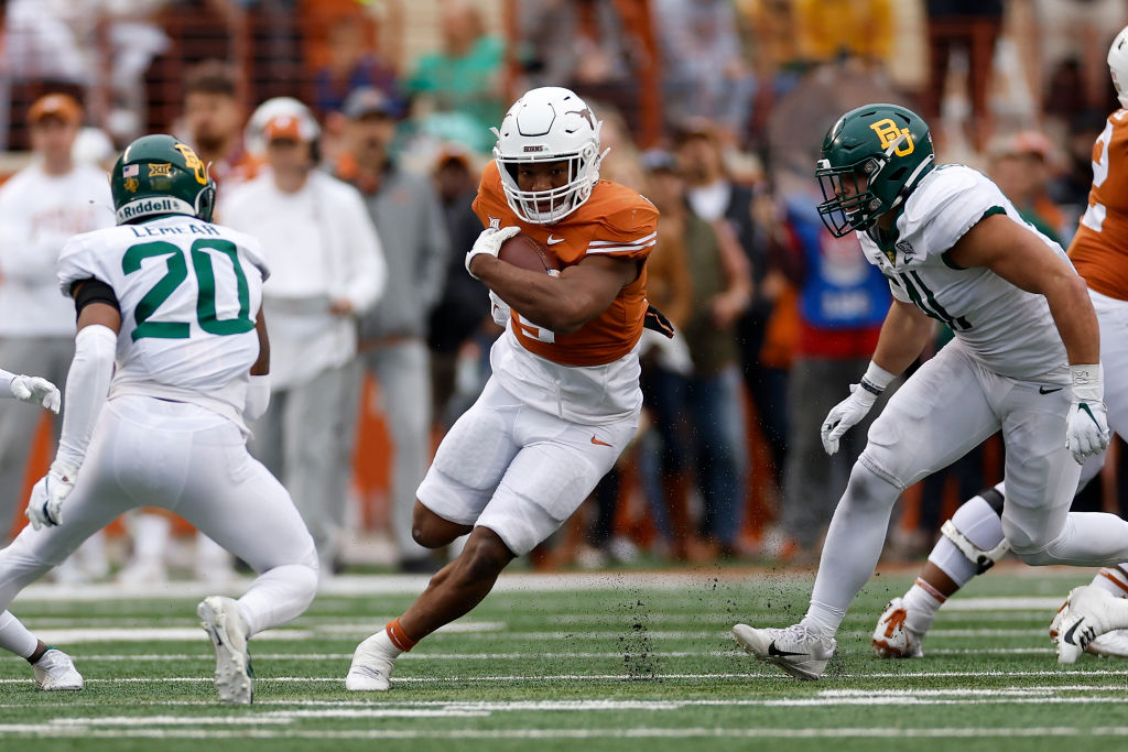 AUSTIN, TEXAS - NOVEMBER 25: Bijan Robinson #5 of the Texas Longhorns runs between Brooks Miller #41 of the Baylor Bears and Devin Lemear #20 in the second half at Darrell K Royal-Texas Memorial Stadium on November 25, 2022 in Austin, Texas. (Photo by Tim Warner/Getty Images)