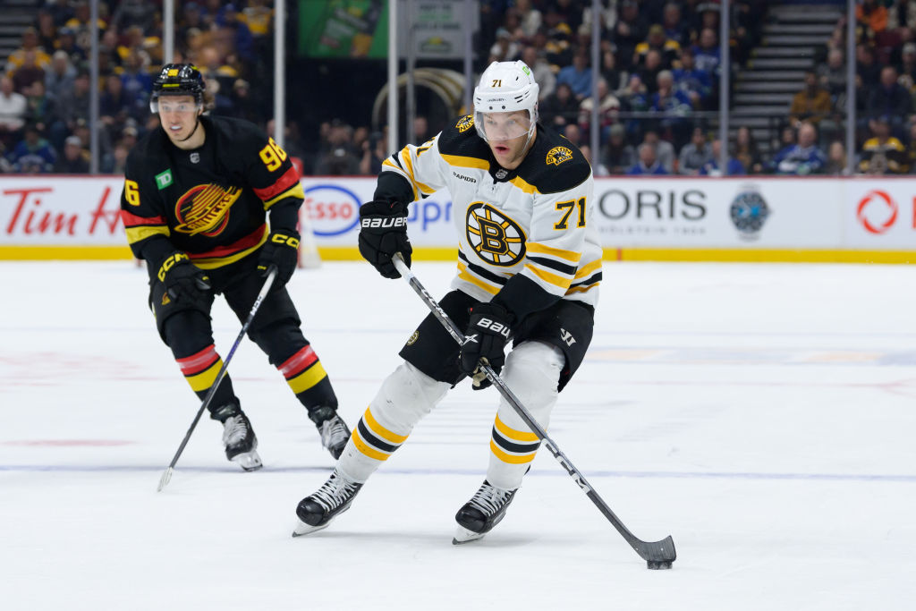 VANCOUVER, CANADA - FEBRUARY 25: Taylor Hall #71 of the Boston Bruins skates with the puck ahead of Andrei Kuzmenko #96 of the Vancouver Canucks during the second period of their NHL game at Rogers Arena on February 25, 2023 in Vancouver, British Columbia, Canada. (Photo by Derek Cain/Getty Images)