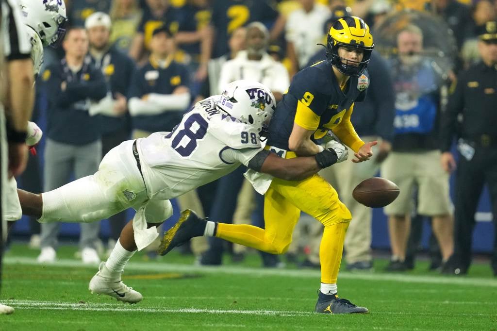 Dec 31, 2022; Glendale, Arizona, USA; TCU Horned Frogs defensive lineman Dylan Horton (98) knocks the football away from Michigan Wolverines quarterback J.J. McCarthy (9) in the first half of the 2022 Fiesta Bowl at State Farm Stadium. Credit: Kirby Lee-USA TODAY Sports