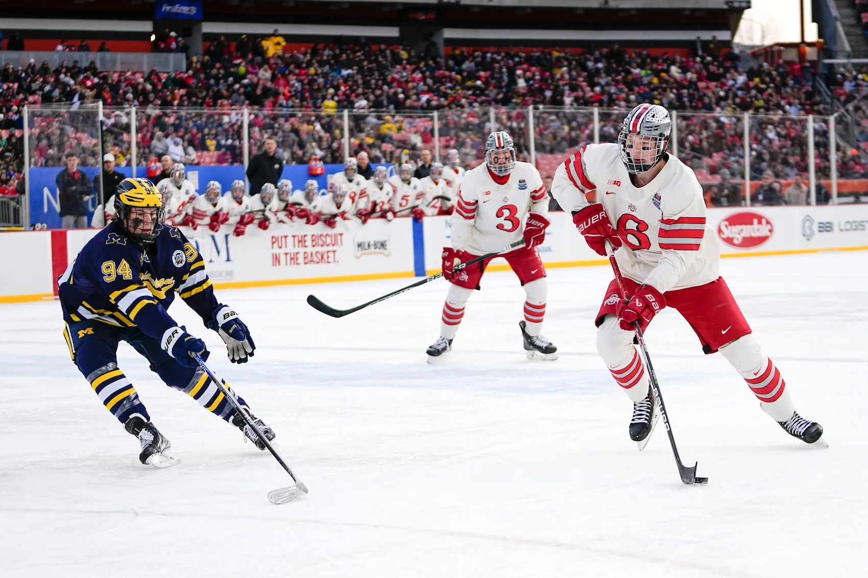 Feb 18, 2023; Cleveland, Ohio, USA; Ohio State Buckeyes defenseman Mason Lohrei (6) moves the puck around Michigan Wolverines forward Mark Estapa (94) during the Faceoff on the Lake outdoor NCAA men‚Äôs hockey game at FirstEnergy Stadium. Mandatory Credit: Adam Cairns-The Columbus Dispatch