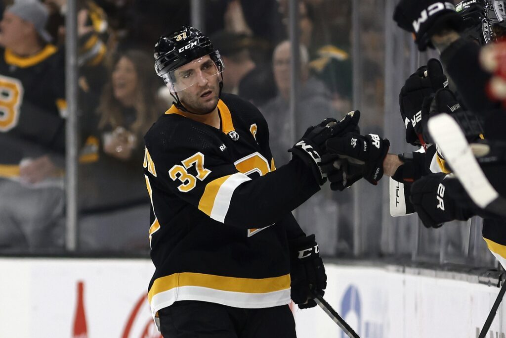 Mar 11, 2023; Boston, Massachusetts, USA; Boston Bruins center Patrice Bergeron (37) is congratulated at the bench after scoring against the Detroit Red Wings during the second period at TD Garden. Mandatory Credit: Winslow Townson-USA TODAY Sports