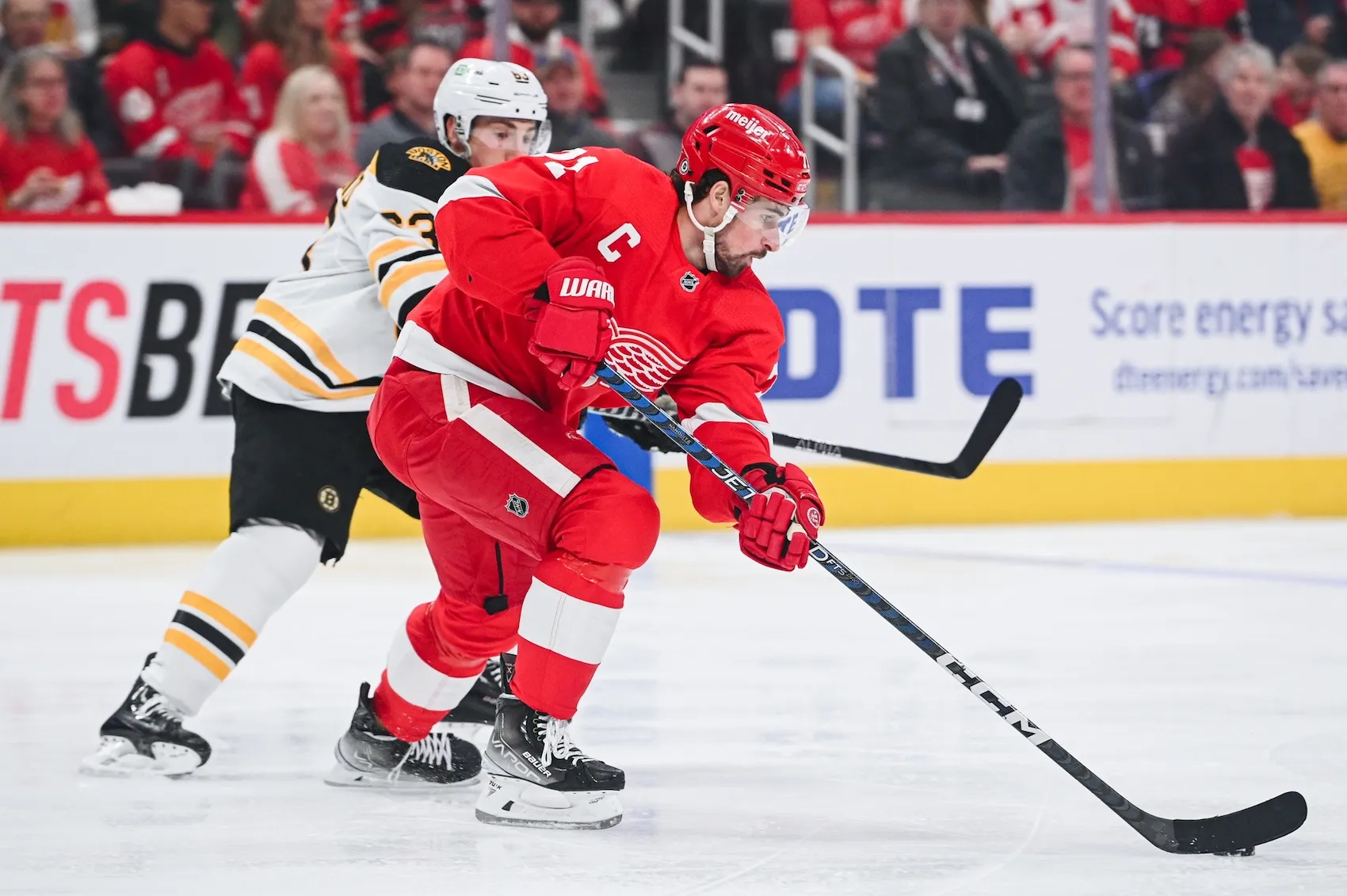 Detroit Red Wings defenseman Moritz Seider (53) defends Boston Bruins left  wing Brad Marchand (63) in