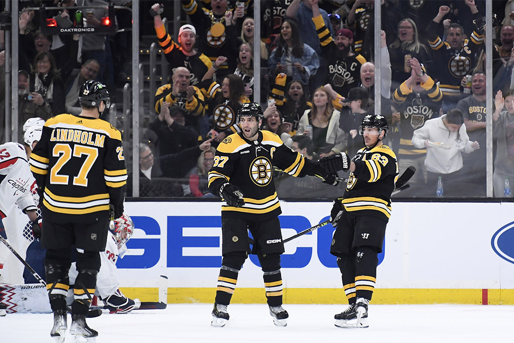 Apr 11, 2023; Boston, Massachusetts, USA; Boston Bruins left wing Brad Marchand (63) reacts with center Patrice Bergeron (37) after scoring a goal during the second period against the Washington Capitals at TD Garden. Mandatory Credit: Bob DeChiara-USA TODAY Sports