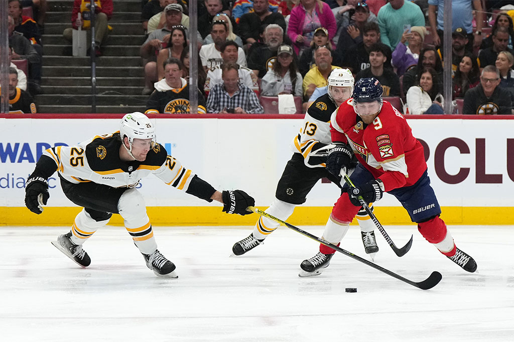 Apr 23, 2023; Sunrise, Florida, USA; Boston Bruins defenseman Brandon Carlo (25) reaches for the puck on Florida Panthers center Sam Bennett (9) during the second period of game four in the first round of the 2023 Stanley Cup Playoffs at FLA Live Arena. Mandatory Credit: Jasen Vinlove-USA TODAY Sports