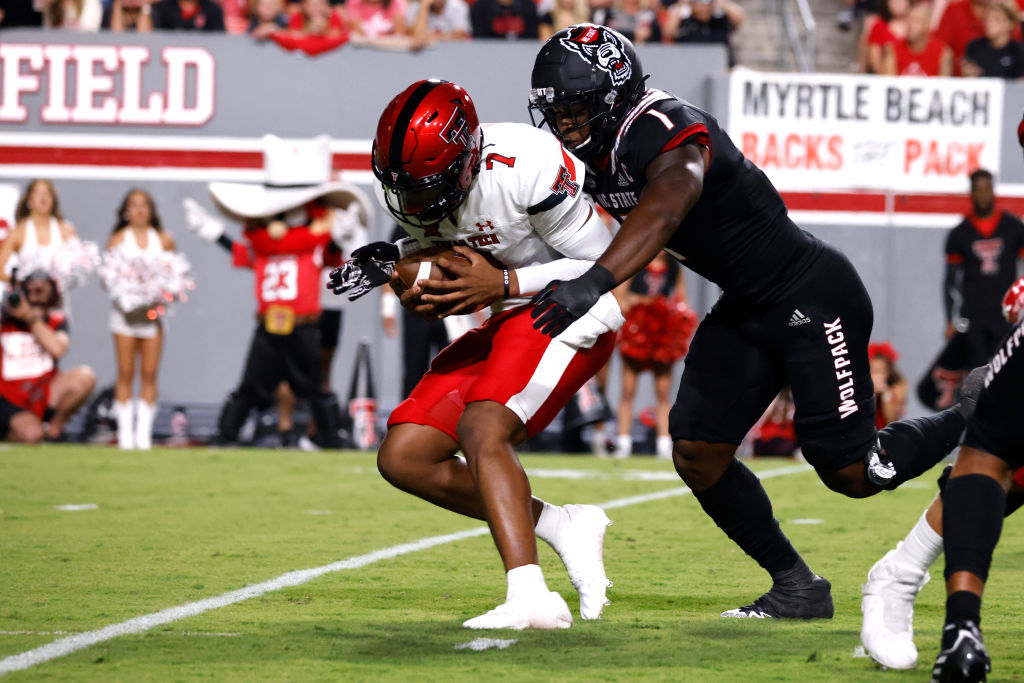 RALEIGH, NC - SEPTEMBER 17: Donovan Smith #7 of the Texas Tech Red Raiders is sacked by Isaiah Moore #1 of the NC State Wolfpack during the first half of their game at Carter-Finley Stadium on September 17, 2022 in Raleigh, North Carolina. (Photo by Lance King/Getty Images)