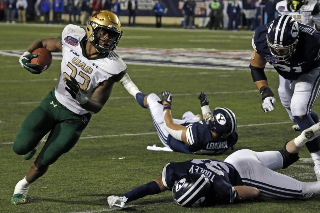 Dec 18, 2021; Shreveport, LA, USA; UAB Blazers running back DeWayne McBride (22) breaks a tackle against BYU Cougars linebacker Max Tooley (31) during the fourth quarter during the 2021 Independence Bowl at Independence Stadium. Credit: Petre Thomas-USA TODAY Sports