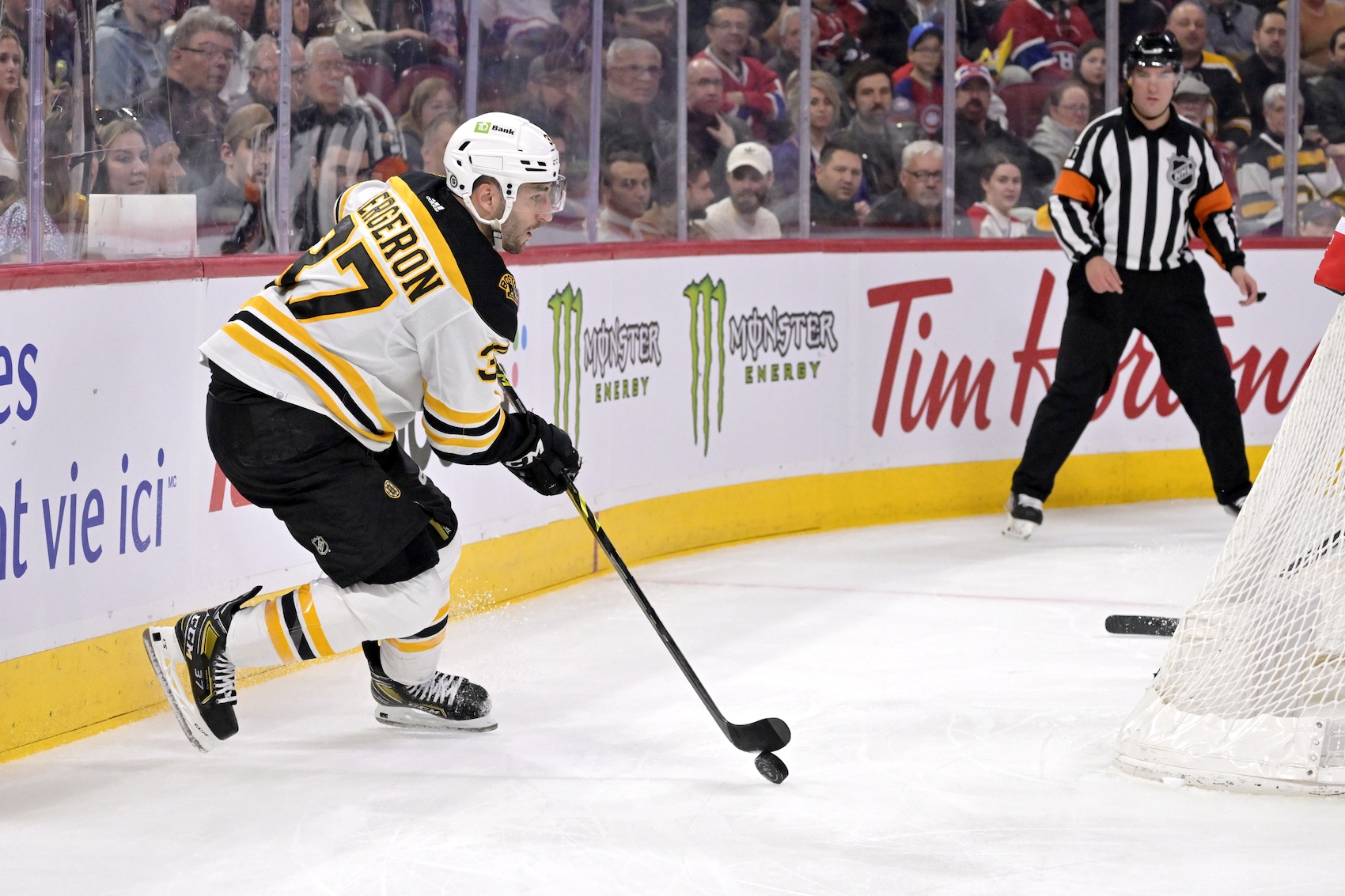 Apr 13, 2023; Montreal, Quebec, CAN; Boston Bruins forward Patrice Bergeron (37) plays the puck behind the Montreal Canadiens net during the first period at the Bell Centre. Mandatory Credit: Eric Bolte-USA TODAY Sports
