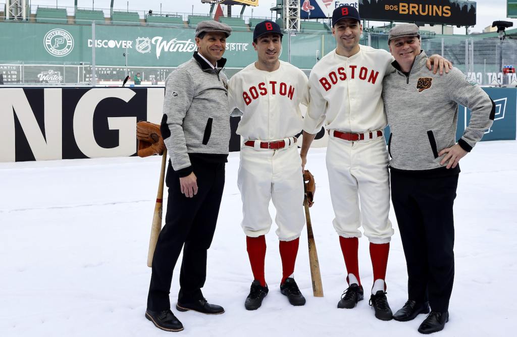 BOSTON, MASSACHUSETTS - JANUARY 02: (L-R) General Manager Don Sweeney, Brad Marchand #63, Patrice Bergeron #37 and head Coach Jim Montgomery of the Boston Bruins pose for a photo before the game against the Pittsburgh Penguins in the 2023 Discover NHL Winter Classic at Fenway Park on January 02, 2023 in Boston, Massachusetts. (Photo by Winslow Townson/Getty Images)