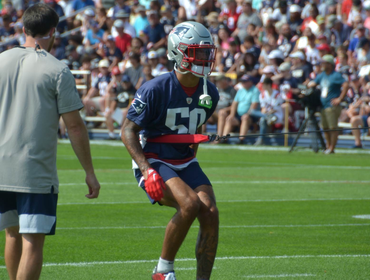 Cornerback Christian Gonzalez runs through a resistance-band drill at Patriots training camp.