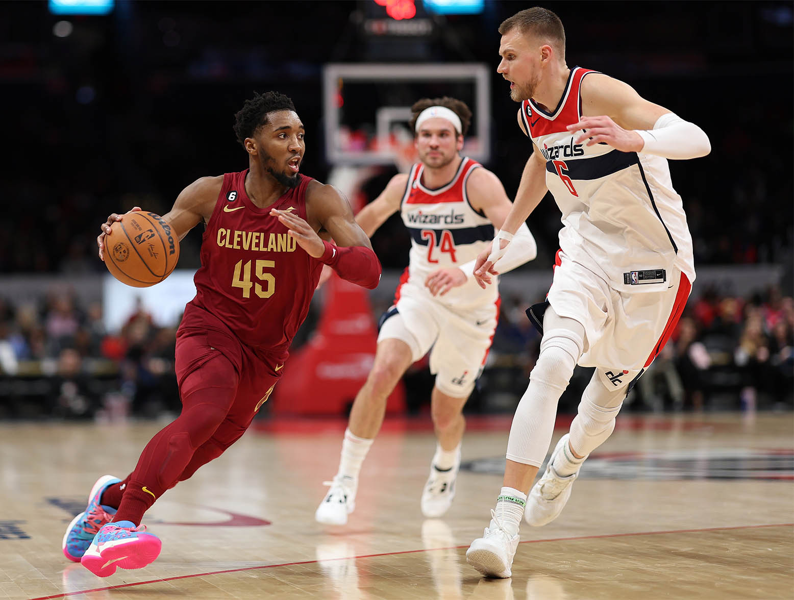 WASHINGTON, DC - FEBRUARY 06: Donovan Mitchell #45 of the Cleveland Cavaliers dribbles past Kristaps Porzingis #6 of the Washington Wizards during the first half at Capital One Arena on February 06, 2023 in Washington, DC. NOTE TO USER: User expressly acknowledges and agrees that, by downloading and or using this photograph, User is consenting to the terms and conditions of the Getty Images License Agreement. (Photo by Patrick Smith/Getty Images)