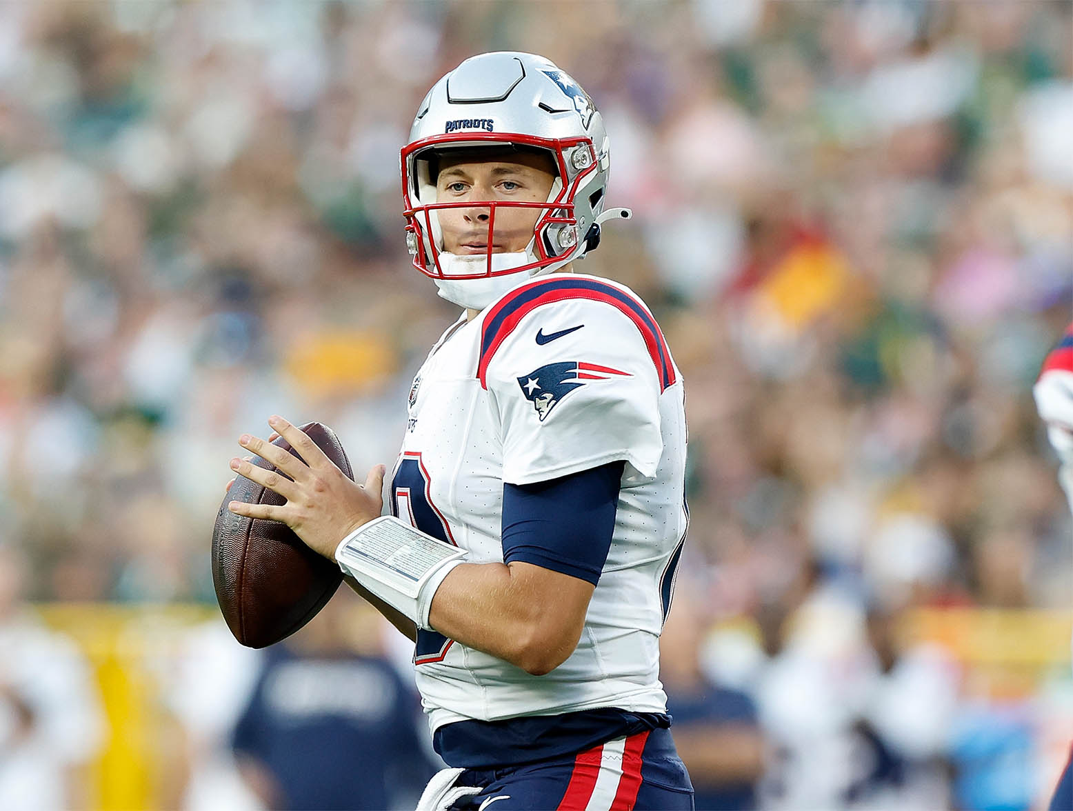 GREEN BAY, WISCONSIN - AUGUST 19: Mac Jones #10 of the New England Patriots drops back to pass during the first half against the Green Bay Packers during a preseason game at Lambeau Field on August 19, 2023 in Green Bay, Wisconsin. (Photo by John Fisher/Getty Images)