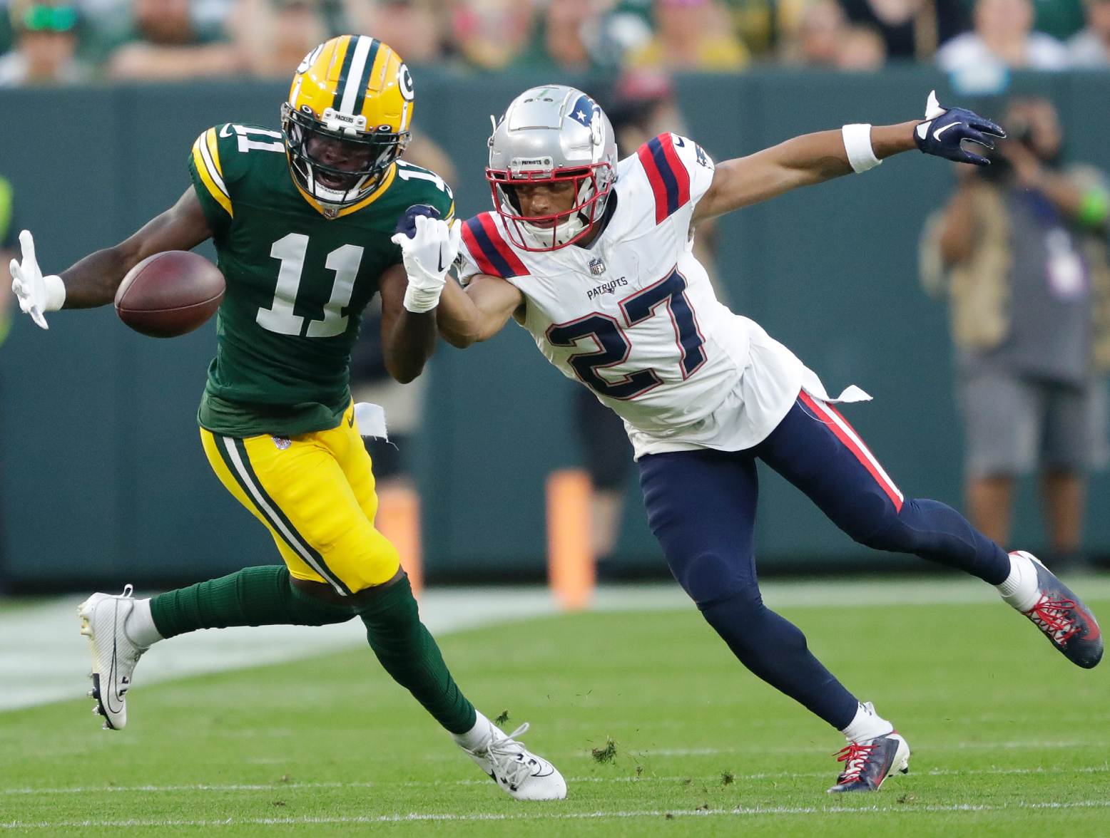Aug 19, 2023; Green Bay, WI, USA;   New England Patriots cornerback Myles Bryant (27) breaks up a pass intended for Green Bay Packers wide receiver Jayden Reed (11) during their preseason football game at Lambeau Field. Credit: Tork Mason-USA TODAY Sports