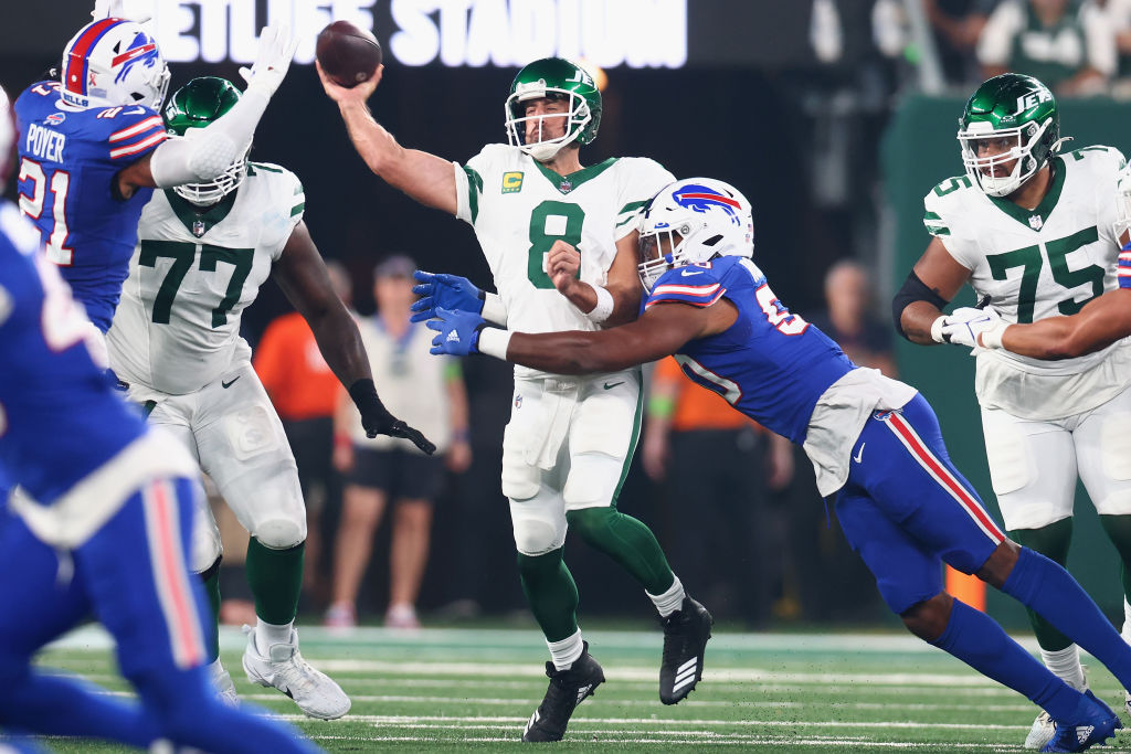 EAST RUTHERFORD, NEW JERSEY - SEPTEMBER 11: Aaron Rodgers #8 of the New York Jets passes as Greg Rousseau #50 of the Buffalo Bills defends in the first quarter of the NFL game at MetLife Stadium on September 11, 2023 in East Rutherford, New Jersey.