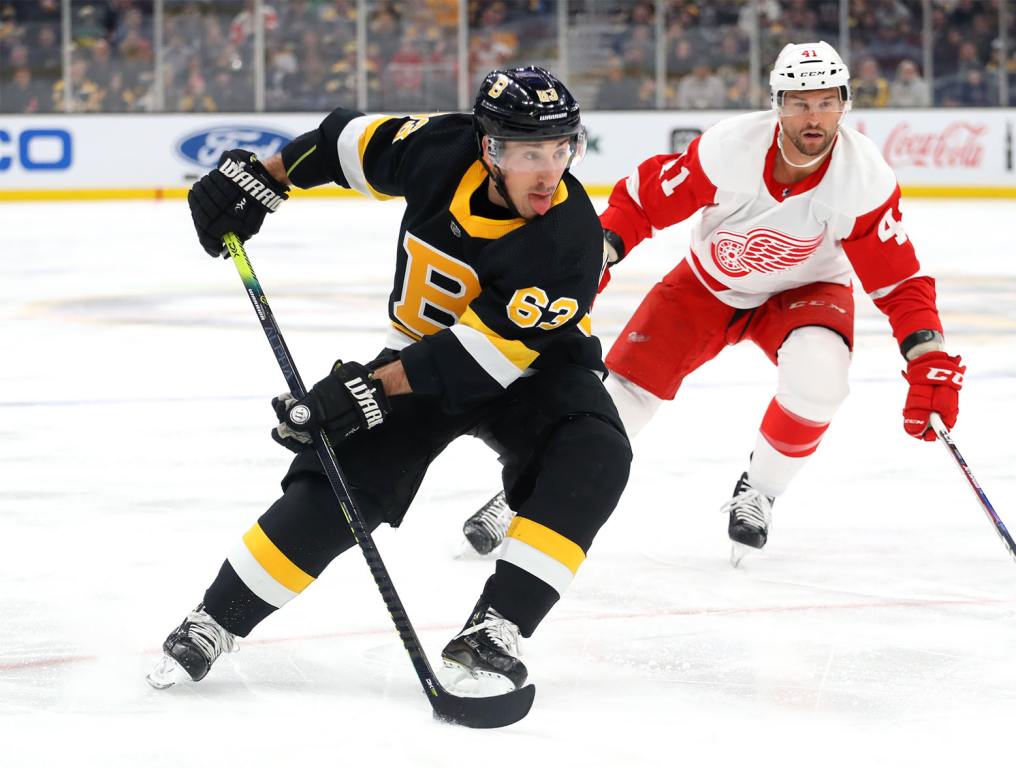 BOSTON, MASSACHUSETTS - FEBRUARY 15: Brad Marchand #63 of the Boston Bruins skates past Luke Glendening #41 of the Detroit Red Wings during the first period at TD Garden on February 15, 2020 in Boston, Massachusetts. (Photo by Maddie Meyer/Getty Images)