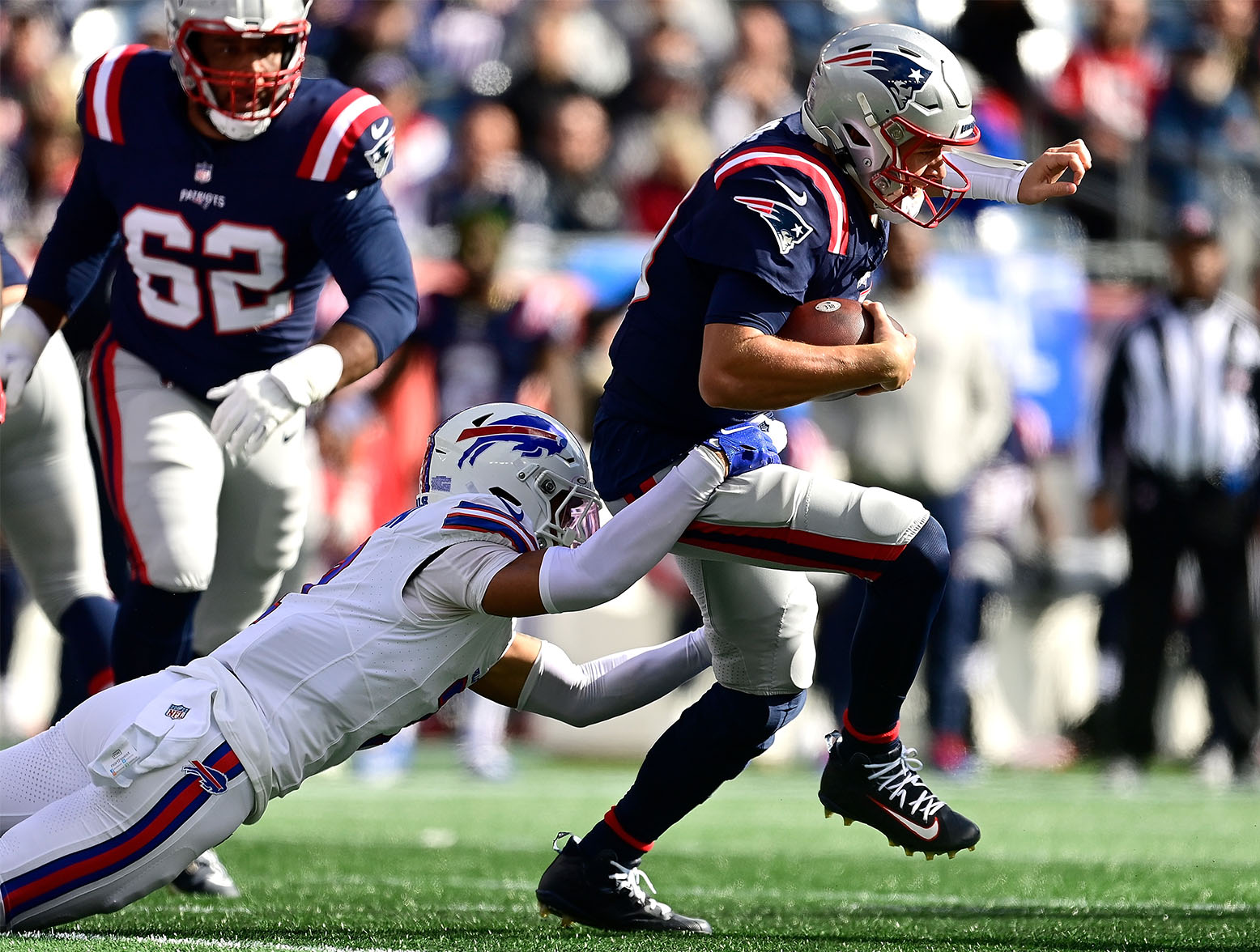 FOXBOROUGH, MASSACHUSETTS - OCTOBER 22: Mac Jones #10 of the New England Patriots scrambles with the ball in the first quarter of the game against the Buffalo Bills at Gillette Stadium on October 22, 2023 in Foxborough, Massachusetts. (Photo by Billie Weiss/Getty Images)