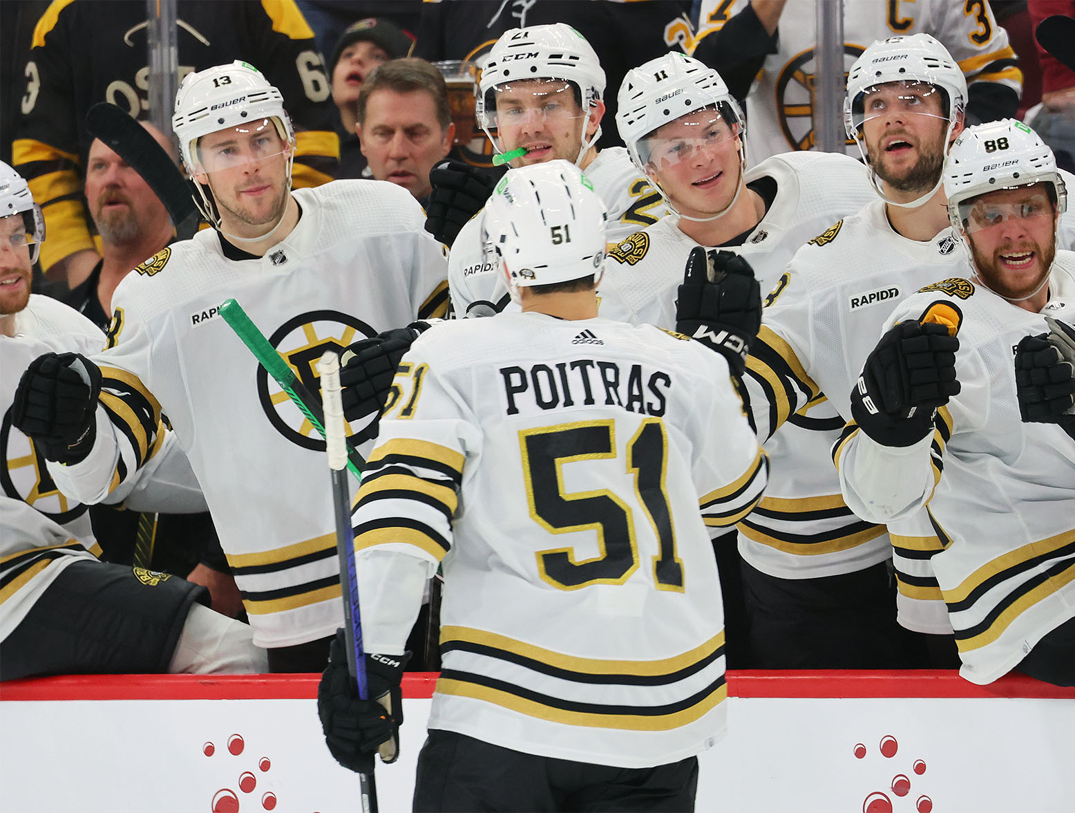 CHICAGO, ILLINOIS - OCTOBER 24: Matthew Poitras #51 of the Boston Bruins fist bumps teammates after scoring a goal against the Chicago Blackhawks during the third period at the United Center on October 24, 2023 in Chicago, Illinois. (Photo by Michael Reaves/Getty Images)