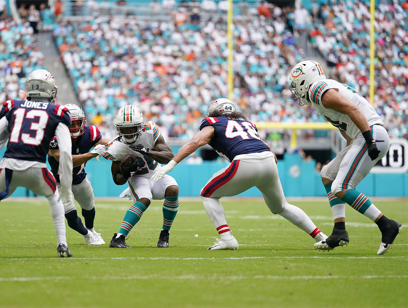 MIAMI GARDENS, FLORIDA - OCTOBER 29: Jahlani Tavai #48 of the New England Patriots tackles De'Von Achane #28 of the Miami Dolphins during the second quarter at Hard Rock Stadium on October 29, 2023 in Miami Gardens, Florida. (Photo by Rich Storry/Getty Images)