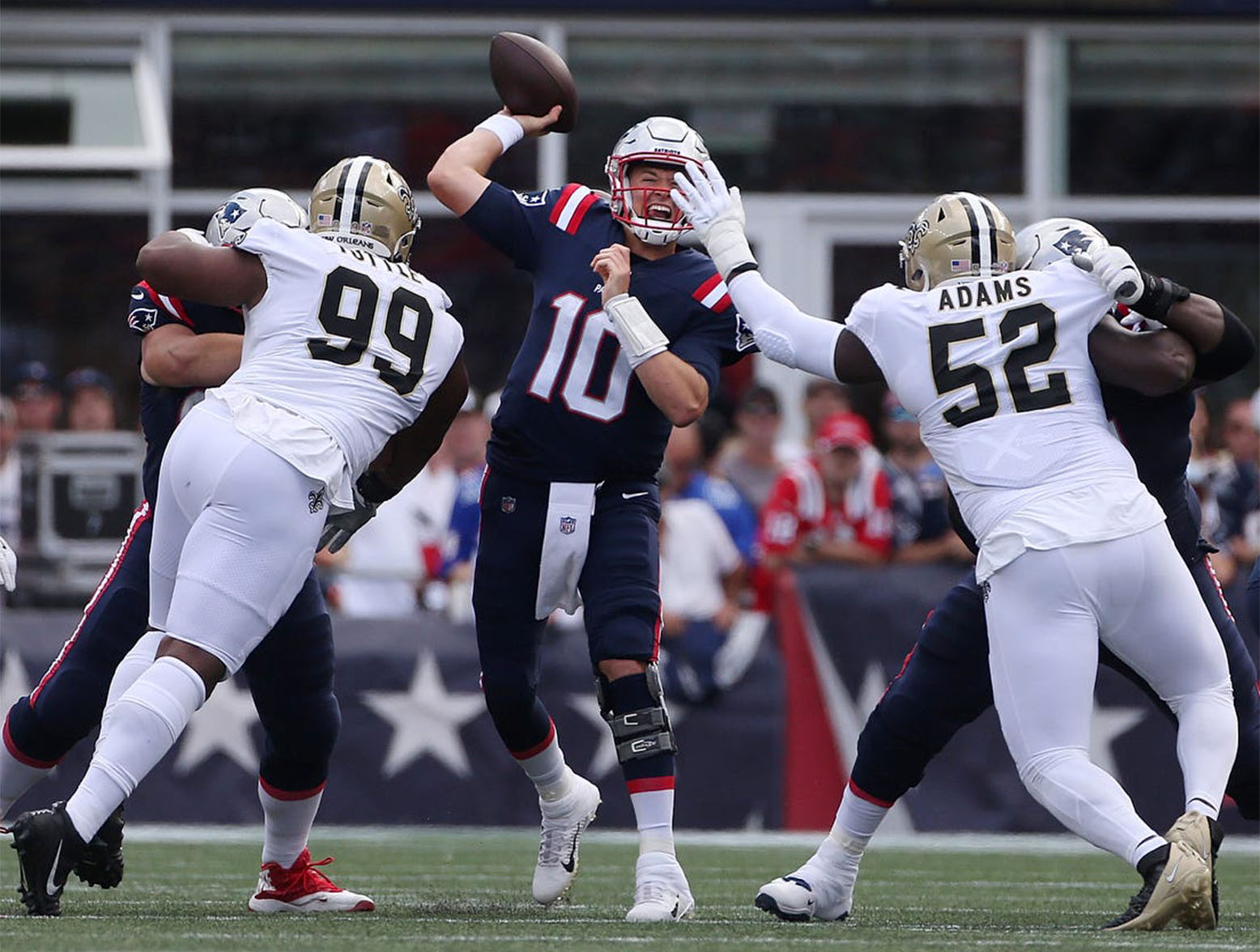 Patriots quarterback Mac Jones releases a pass under pressure from Saints defenders. (Syndication: The Providence Journal)