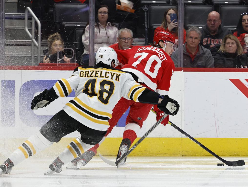 Apr 5, 2022; Detroit, Michigan, USA; Detroit Red Wings center Oskar Sundqvist (70) skates with the puck defended by Boston Bruins defenseman Matt Grzelcyk (48) in the second period at Little Caesars Arena. Mandatory Credit: Rick Osentoski-USA TODAY Sports