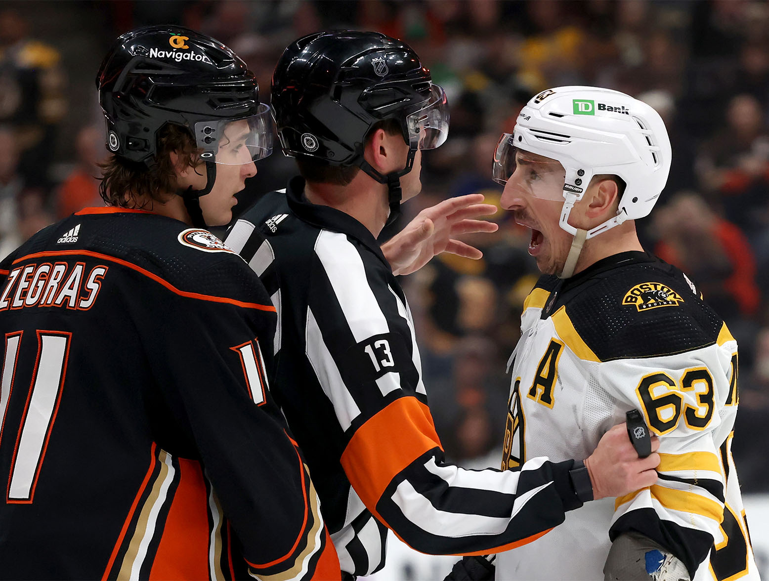 Jan 8, 2023; Anaheim, California, USA; Boston Bruins left wing Brad Marchand (63) yells at Anaheim Ducks center Trevor Zegras (11) during the first period at Honda Center. Mandatory Credit: Jason Parkhurst-USA TODAY Sports