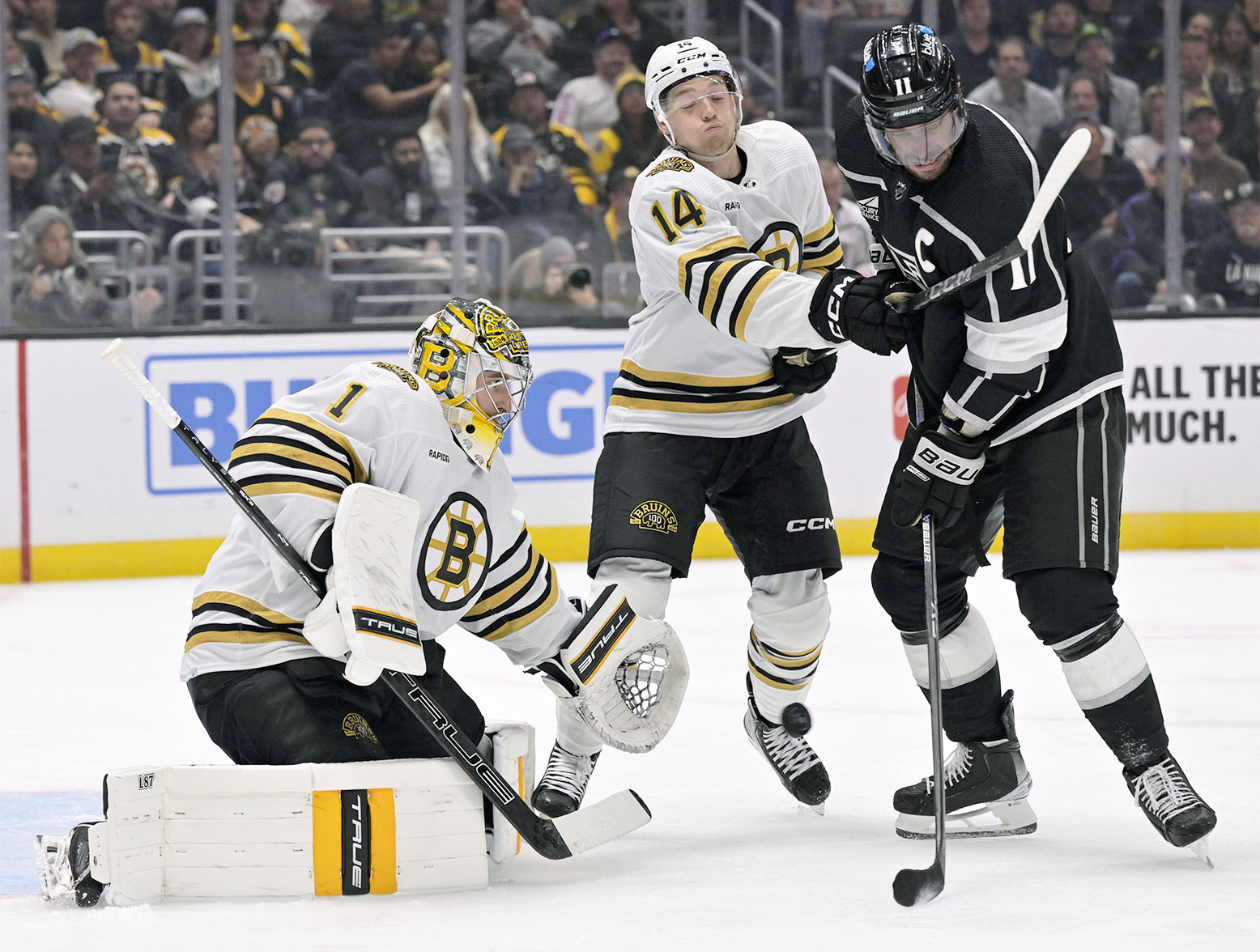 Oct 21, 2023; Los Angeles, California, USA; Boston Bruins goaltender Jeremy Swayman (1) stops a shot with defenseman Ian Mitchell (14) defending against Los Angeles Kings center Anze Kopitar (11) during the second period at Crypto.com Arena. Mandatory Credit: Alex Gallardo-USA TODAY Sports