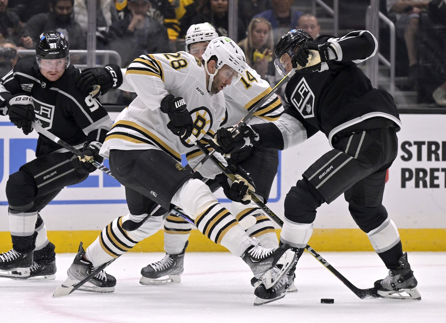 Oct 21, 2023; Los Angeles, California, USA; Boston Bruins defenseman Derek Forbort (28) vies to control the puck with Los Angeles Kings center Trevor Lewis (right) during the second period at Crypto.com Arena. Mandatory Credit: Alex Gallardo-USA TODAY Sports