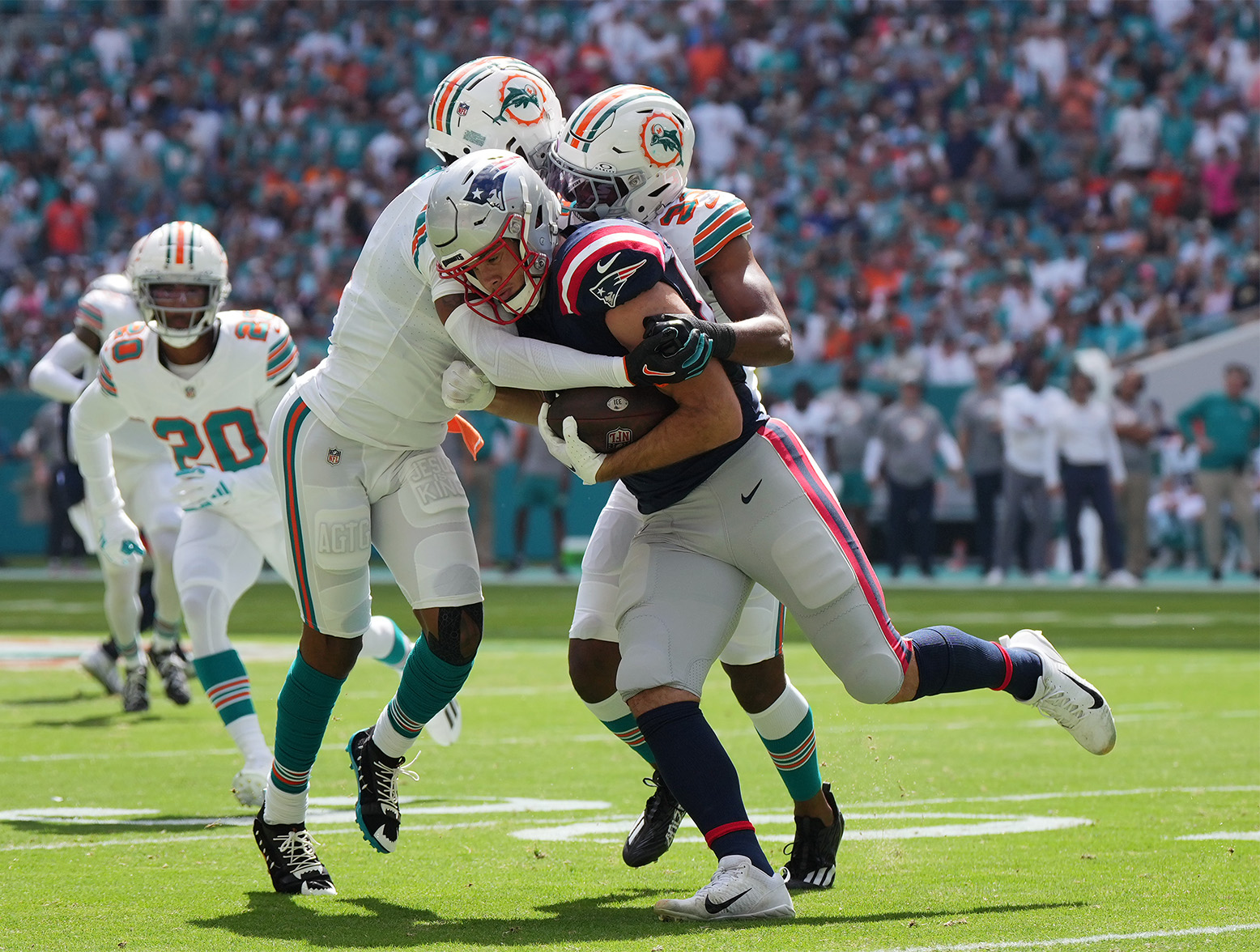 Oct 29, 2023; Miami Gardens, Florida, USA; Miami Dolphins cornerback Jalen Ramsey (5) and Miami Dolphins cornerback Eli Apple (33) bring down New England Patriots tight end Hunter Henry (85) during the first half at Hard Rock Stadium. Mandatory Credit: Jasen Vinlove-USA TODAY Sports