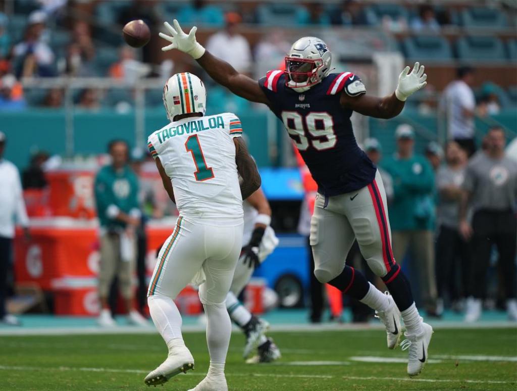 Oct 29, 2023; Miami Gardens, Florida, USA; New England Patriots defensive end Keion White (99) reaches for the pass of Miami Dolphins quarterback Tua Tagovailoa (1) during the first half at Hard Rock Stadium. Mandatory Credit: Jasen Vinlove-USA TODAY Sports