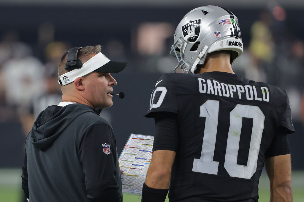 LAS VEGAS, NEVADA - SEPTEMBER 24: Head coach Josh McDaniels of the Las Vegas Raiders speaks with Jimmy Garoppolo #10 of the Las Vegas Raiders in the game against the Pittsburgh Steelers during the fourth quarter at Allegiant Stadium on September 24, 2023 in Las Vegas, Nevada. (Photo by Ethan Miller/Getty Images)