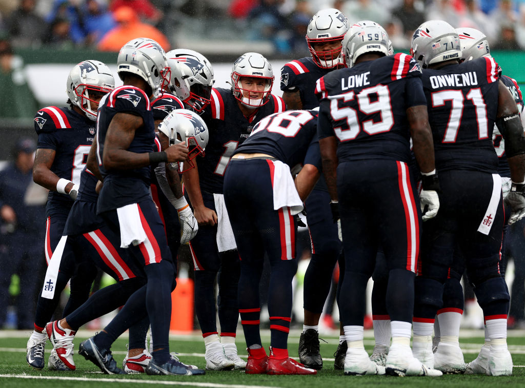 EAST RUTHERFORD, NEW JERSEY - SEPTEMBER 24: Mac Jones #10 of the New England Patriots stands in the huddle in the first half against the New York Jets at MetLife Stadium on September 24, 2023 in East Rutherford, New Jersey. (Photo by Elsa/Getty Images)