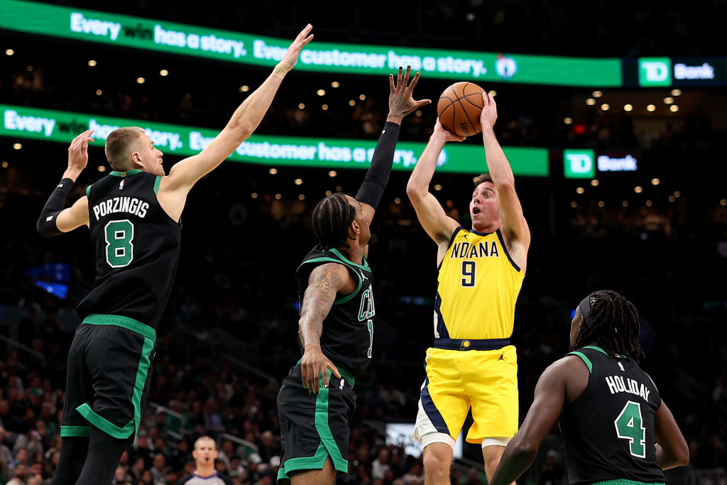 BOSTON, MASSACHUSETTS - NOVEMBER 01: T.J. McConnell #9 of the Indiana Pacers takes a shot with pressure from Kristaps Porzingis #8, Oshae Brissett #12, and Jrue Holiday #4 of the Boston Celtics during the second quarter at TD Garden on November 01, 2023 in Boston, Massachusetts. NOTE TO USER: User expressly acknowledges and agrees that, by downloading and or using this photograph, User is consenting to the terms and conditions of the Getty Images License Agreement.  (Photo by Maddie Meyer/Getty Images)